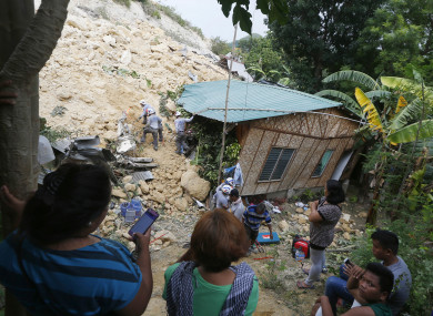 Relatives watch as rescuers dig through the rubble