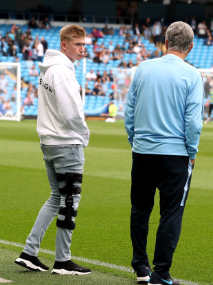 The Belgian (pictured with Brian Kidd) wearing a brace on his leg early on in the recovery.
