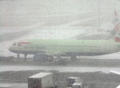 Snow showers cover Heathrow Airport in West London. Many UK airports are shut, and bus services in Ireland have been affected by poor weather.