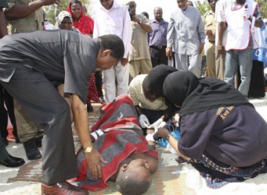 The president of Zanzibar, Ali Mohammed Shein, left, helps a survivor.