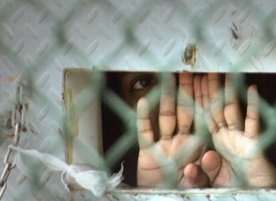 In this Dec. 4, 2006 file photo reviewed by the U.S. Military, a detainee peers out from his cell inside the Camp Delta detention facility at the Guantanamo Bay US Naval Base in Cuba.