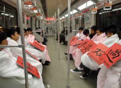 Young men wrapped in quilts are wearing signboards with their contact information to show their desire for a wife ahead of next week's Singles Day. 11/11/11 is a Chinese pop culture holiday for people who are still living the single life.