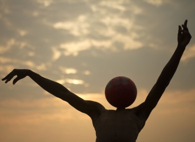 A youth plays with a ball on the beach of the Atlantic ocean near the port Bata, Equatorial Guinea, Thursday, Jan. 26, 2012.