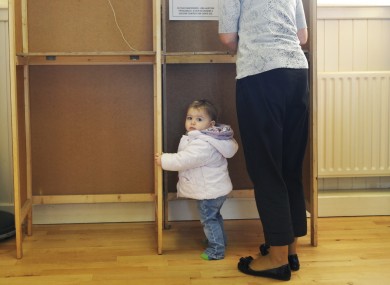 Síofra Hughes, 1, waits as her mother Siobhán votes in October's presidential election.
