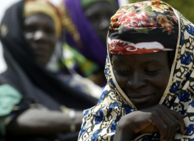 Women wait to receive food at the (CARE) food distribution centre in Douloukou in August 2005.