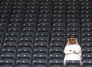 A spectator watches from an empty stand during the third free practice ahead of the Bahrain Formula One Grand Prix at the Formula One Bahrain International Circuit in Sakhir