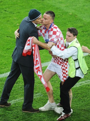 A Croatia fan runs on and kisses Croatia manager Slaven Bilic last night.