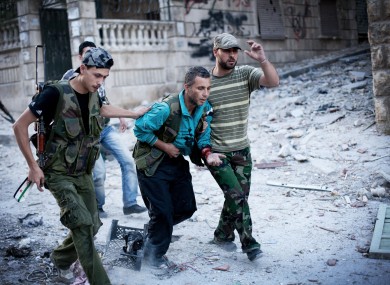 Free Syrian Army soldiers help a severely wounded fighter after he was shot by a Syrian Army sniper in the Izaa district of Aleppo, Syria