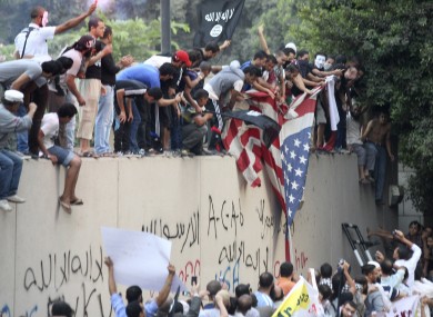 Protesters destroy an American flag pulled down from the US embassy in Cairo yesterday