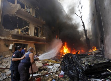 Lebanese firefighters extinguish burning cars at the scene of an explosion in the mostly Christian neighborhood of Achrafiyeh, Beirut.