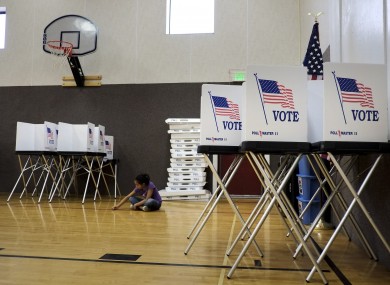 Jaylynn Notafraid, 9, sits amid voting booths in the gym at Crow Elementary School in Crow Agency in Montana.