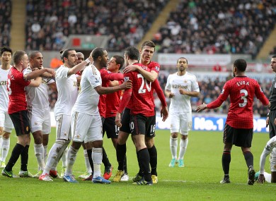 Match referee Michael Oliver (right) looks on as a melee on the pitch erupts during a confrontation between Swansea City's Ashley Williams (third left) and Manchester United's Robin van Persie (centre right).
