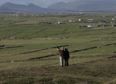 Tourists use their iPad to video the landscape as the Atlantic Ocean reaches land near Clogher Head on the Dingle Peninsula.