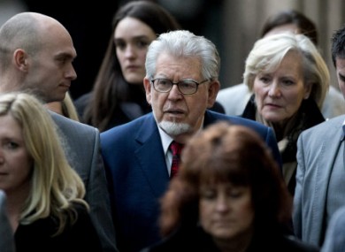 Rolf Harris, center, leaves amidst a group of people who accompanied him to his hearing at Southwark Crown Court in London.