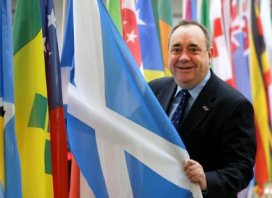 Scotland's First Minister Alex Salmond views a saltire flag at Glasgow Airport.