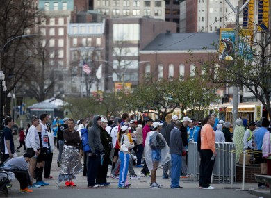 Runners queue to board busses ahead of the 118th Boston Marathon