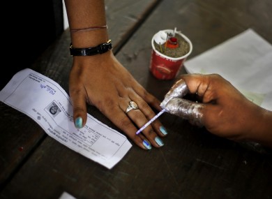 An election officer applies an indelible ink mark on the finger of a woman after voting Dibrugarh, in the northeastern state of Assam, India.