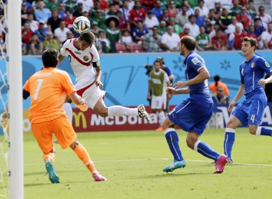 Costa Rica's Bryan Ruiz heads the ball to score his side's first goal over Italy's goalkeeper Gianluigi Buffon.