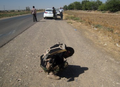 A Kurdish security officer covers his face after seeing several dead bodies in Kirkuk, Iraq.
