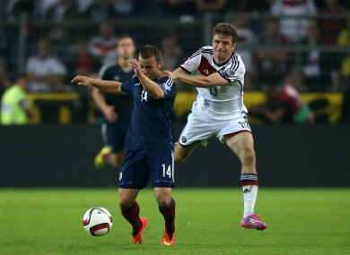 Germany's Thomas Mueller (right) pulls back Scotland's Shaun Maloney