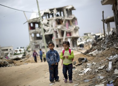 Palestinian school children walk through destroyed houses in Gaza City's Shijaiyah neighborhood last Sunday.