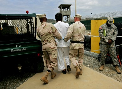 File photo of a Guantanamo detainee being escorted by US military personnel.