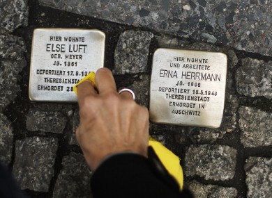 A woman cleans a so-called 'Stolperstein' in Berlin.