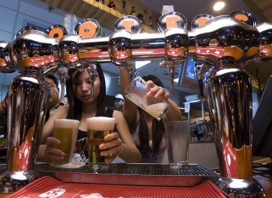 Waitresses fill beer glasses at the Beijing outlet for Hooters
