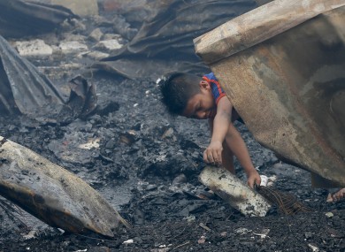 A boy retrieves some items following an early morning fire that engulfed the poor neighbourhood of Tondo, a district in Manila, while celebrating the New Year.