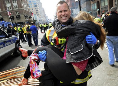 Boston Firefighter James Plourde carries Victoria McGrath from the scene after a bombing near the Boston Marathon finish line.