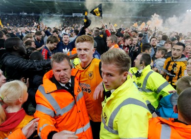 Hull's Sam Clucas gets escorted off the pitch after the final whistle.