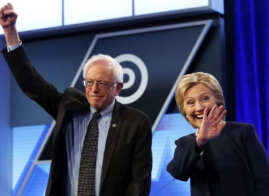 In this 9 March 2016 photo, Sanders and Clinton stand together before the start of a presidential debate at Miami-Dade College in Miami.