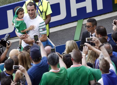 Ireland's John O'Shea holds a young boy in front of supporters after the Euro 2016 round of 16 soccer match between France and Ireland.