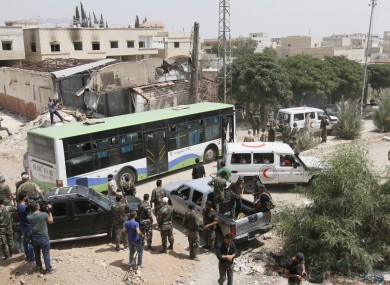 Syrian government buses and Syrian Arab Red Crescent ambulances at the entrance of Darayya, southwest of Damascus.