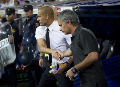 In this Sunday Aug. 14, 2011 file picture, the then Real Madrid's coach Jose Mourinho from Portugal, right, shakes hands with former Barcelona's coach Josep Guardiola before their Super Cup first leg soccer match.