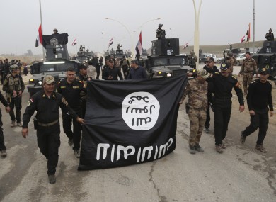 Iraq's special forces troops hold a flag of the Islamic State group in Mosul last month.