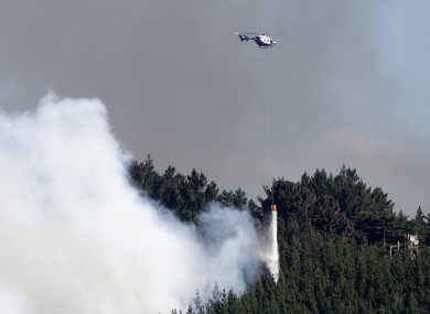 A helicopter dumps water on the fire.