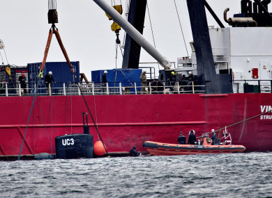 The turret of UC3 Nautilus is seen by the side of a salvage vessel during the operation.
