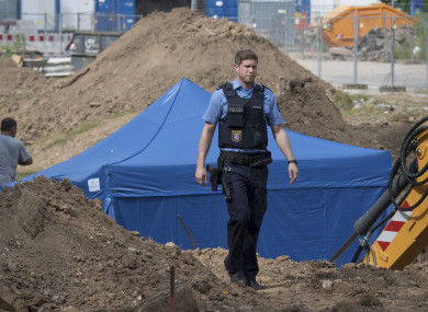 A police officer passes a blue tent that was set up over the 1.8 tonne bomb of the type dropped by British bombers during World War II.