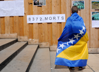 A boy wrapped in a Bosnian flag commemorates the 20th anniversary of the Bosnian war in 2015.