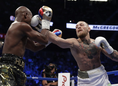 Conor McGregor hits Floyd Mayweather Jr in a super welterweight boxing match.