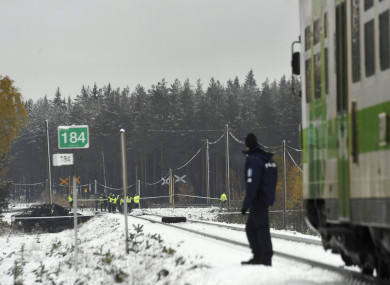 Rescue, military personnel and a policeman gather at the railroad crossing of the crash.