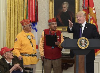 President Donald Trump, right, speaks during a meeting with Navajo Code Talkers including Fleming Begaye Sr, seated left, Thomas Begay, second from left, and Peter MacDonald, second from right, in the Oval Office.