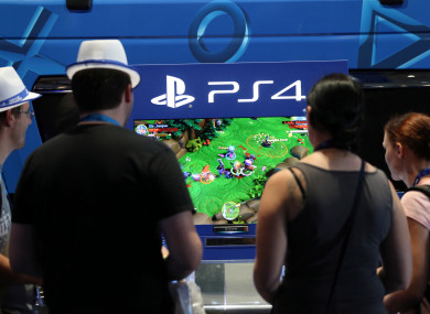 Visitors play Sony's Playstation 4 at Gamescom in Cologne.