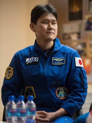 Expedition 54 flight engineer Norishige Kanai is seen in quarantine behind glass during a press conference in December 2017.