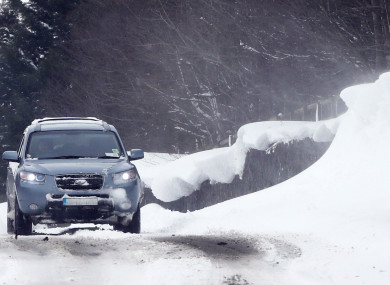 A car passing snow drifts at the Curragh in Kildare yesterday.