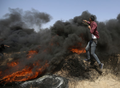 Palestinians hurl stones and burn tires near the fence of the Gaza Strip's border with Israel, during a protest east of Khan Younis, in the Gaza Strip.