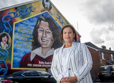 McDonald on front of a mural of Bobby Sands on the Falls Road in Belfast.