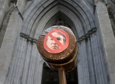 A protester holds a gavel with a picture of Brett Kavanaugh in New York.