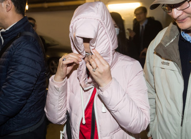 A woman hides her face while leaving British Columbia Supreme Court, in Vancouver on Tuesday